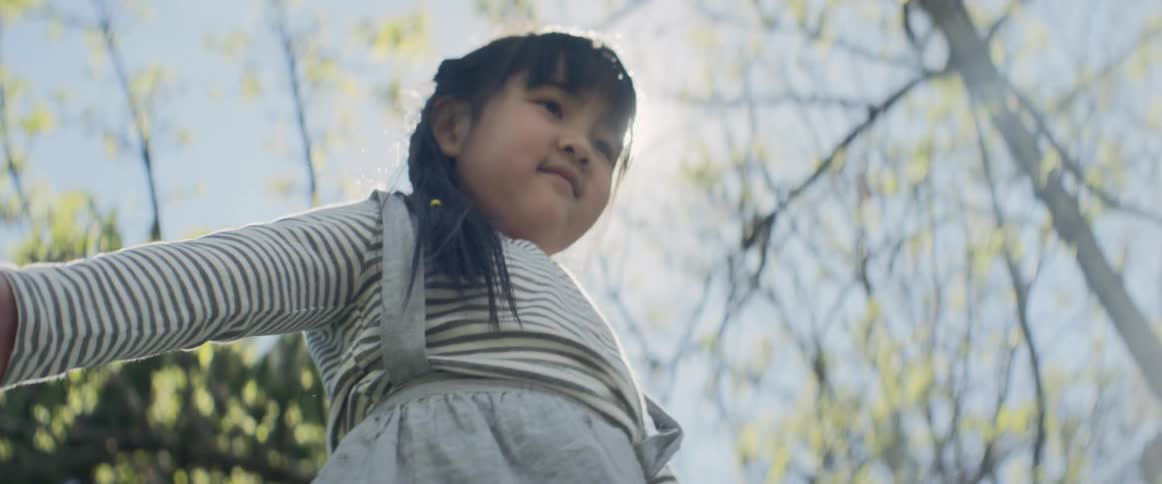 Asian little girl plays outdoors on a sunny day