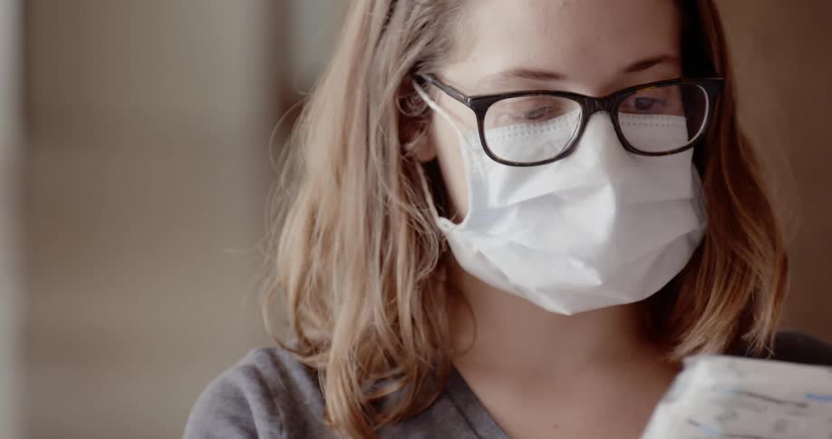 Nurse unpacking a box of face masks while wearing one