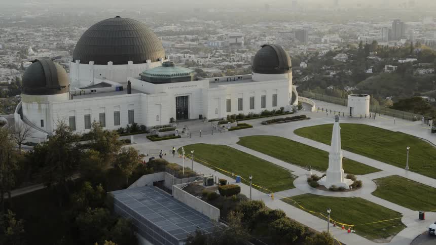 A religious building sits on raised land with a city in the background
