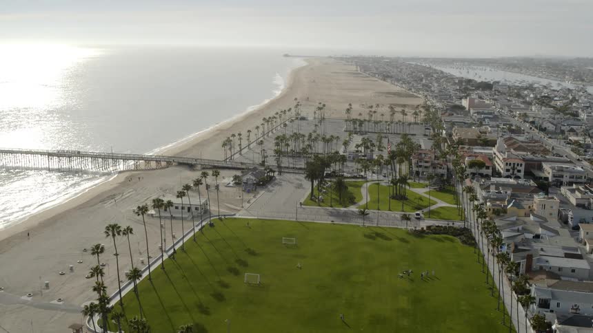 A beachside neighborhood with people walking on the boardwalk