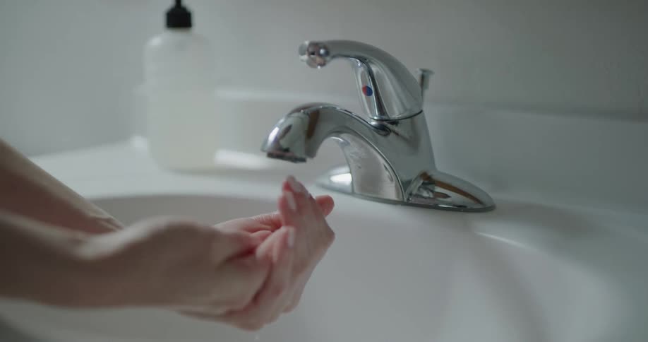 A person puts some soap in their hands and begins cleaning them