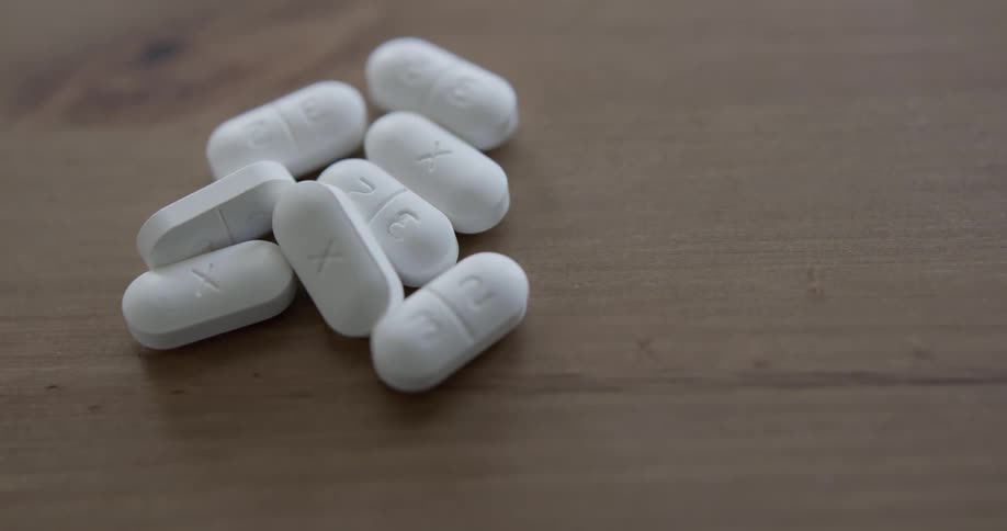 A person pours their pills out on the table