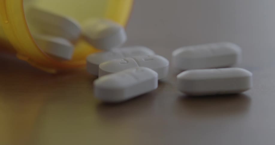 A pill container drops and capsules fall out