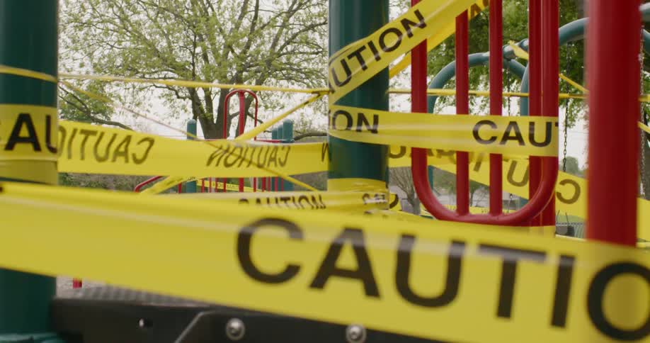 Yellow caution tape is wrapped around playground equipment to keep people away