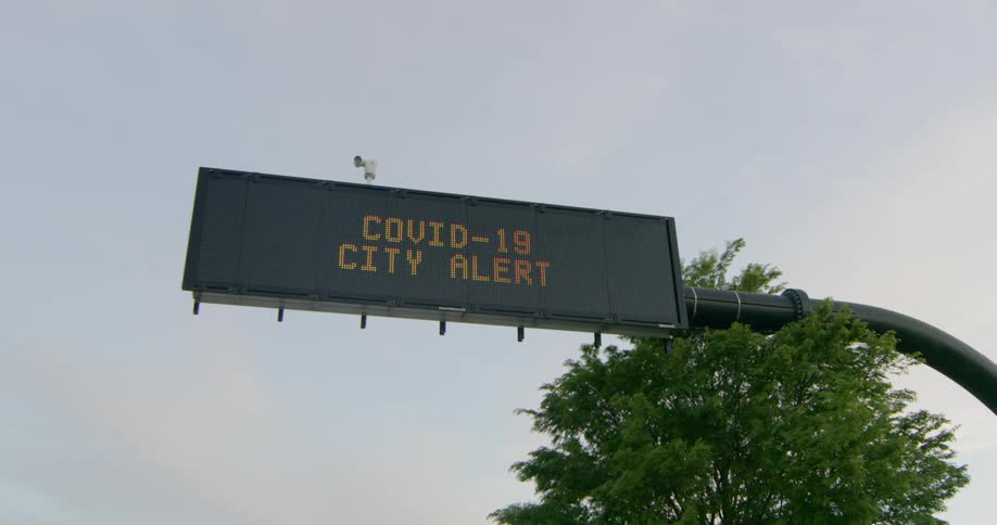 A covid 19 city alert displayed on a street sign