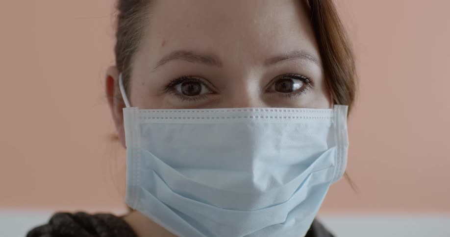 Woman wearing a face mask looks at the camera