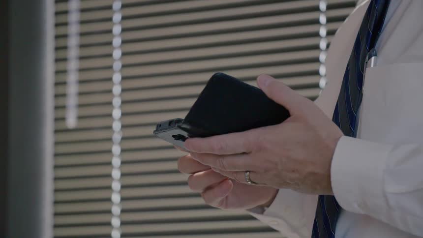 Business man checks cell phone at office