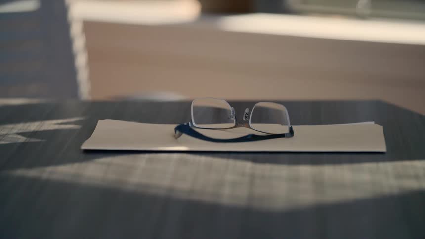 A pair of glasses is sitting on a desk