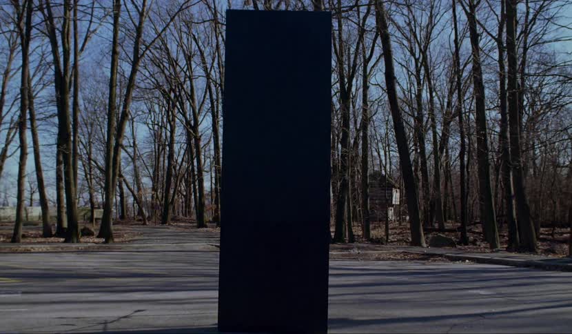 A black object sits in a parking lot