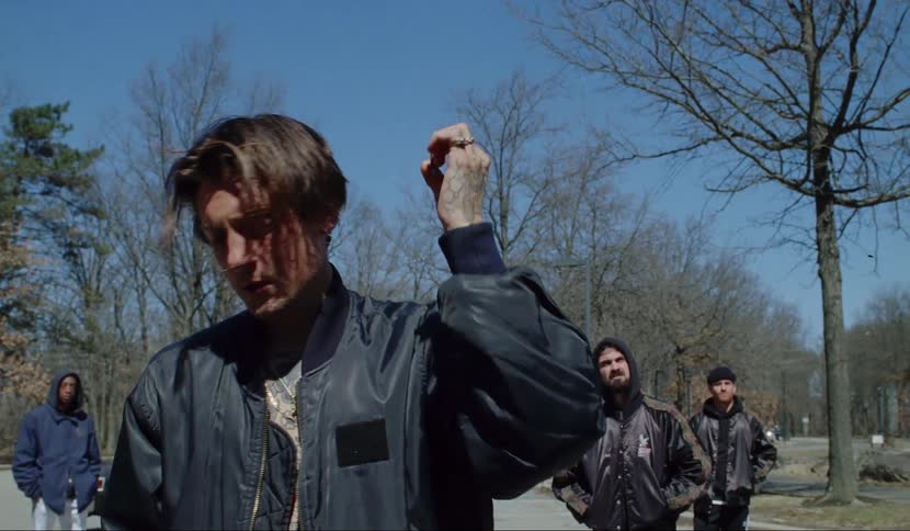 A man smokes a cigarette and touches his hair