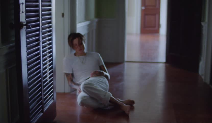 A man collapsing against a doorway in a hall