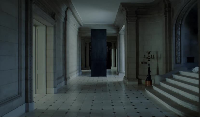 A white hallway with a black pillar