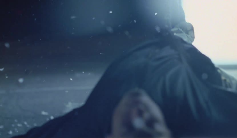 A man is hanging by strings while its snowing outside