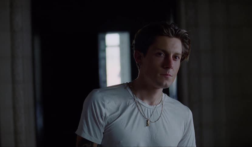 A man standing in a hallway trying to get a good look at something off screen