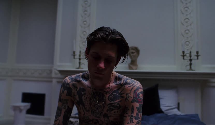 A man is sitting on a bed in a bedroom