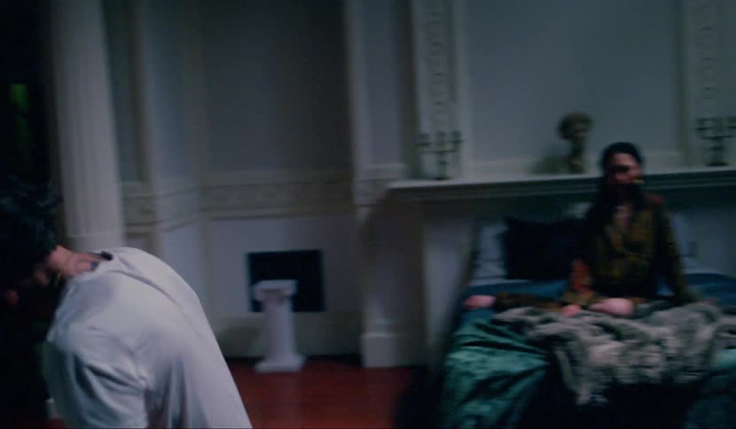 Man goes crazy while asian woman sits on the bed in the room