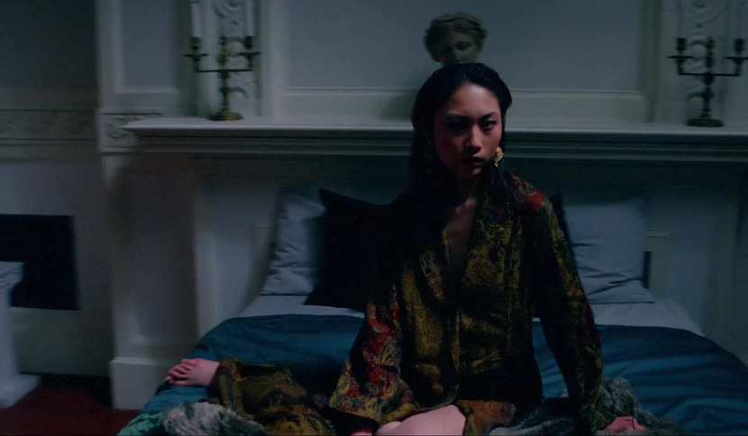 A woman sitting on a bed staring