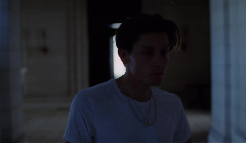 A man is walking in a dark hallway