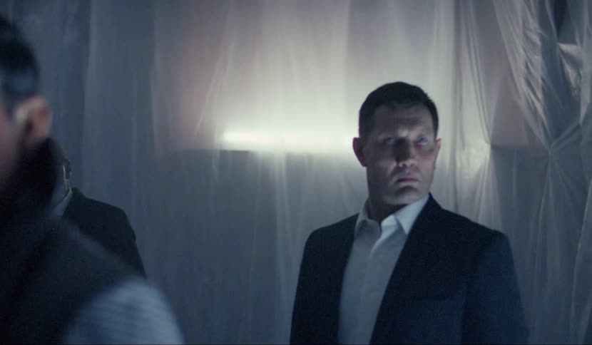 Group of middle aged men stand still on a dark room