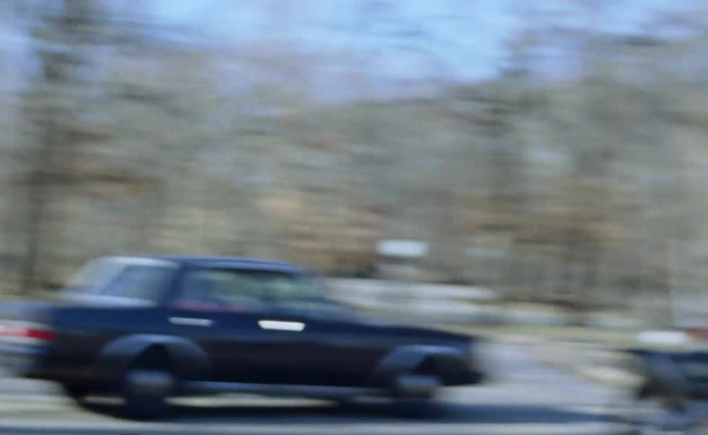 A car on the street with trees in the background