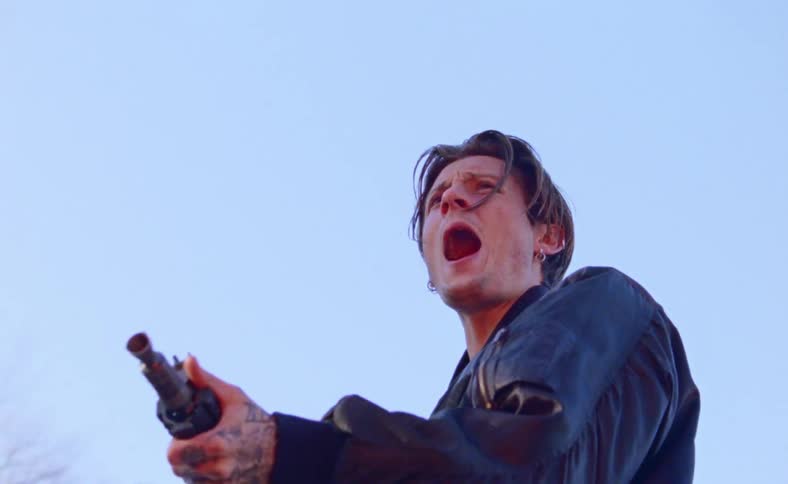 A man with a machine gun walks up and starts screaming and shooting