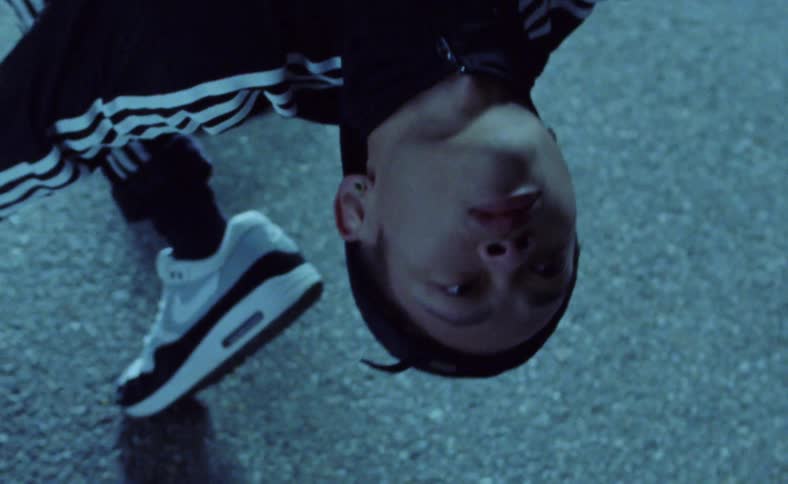 A person bends over backwards and then hangs still