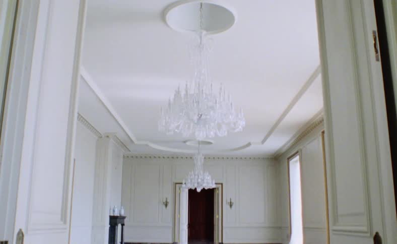 A room with chandeliers doorways and windows