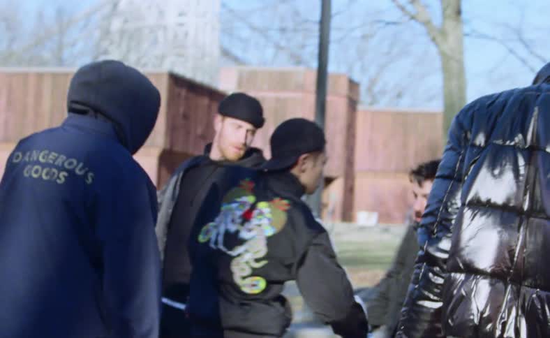 A group of men dance hip hop in a parking lot