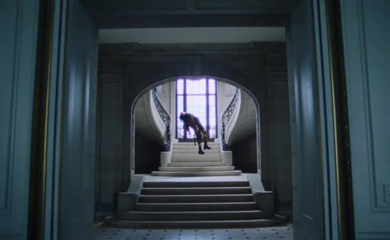 A man is hanging in a room above a staircase