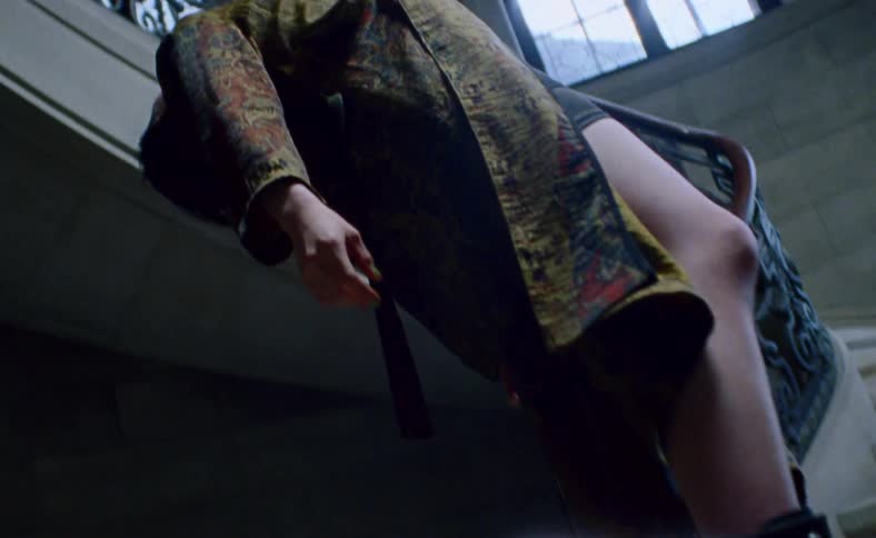 A woman hanging from a wire at the bottom of a staircase