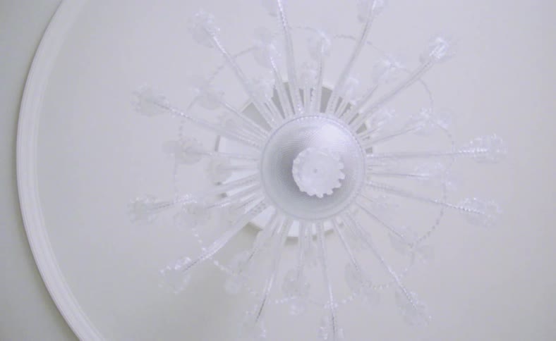 Arms spread out like spokes on white circular surface and rotate