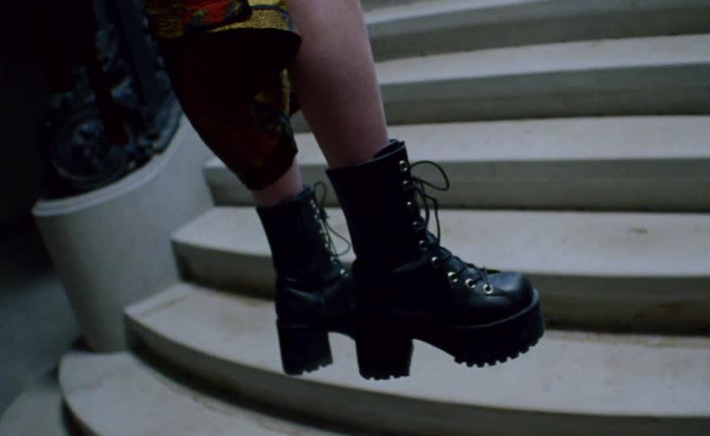 Woman in boots floating over staircase inside house