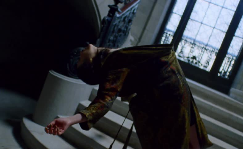 A female that is tied to a stairwell flings herself back to hang