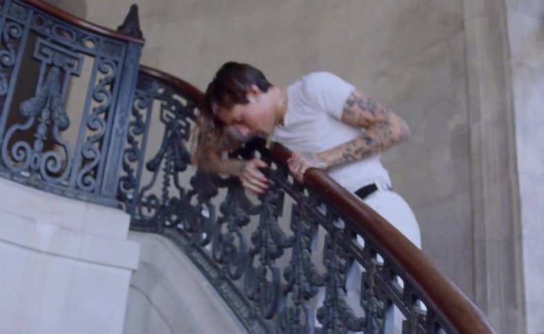 A man is stumbling as he walks up a staircase