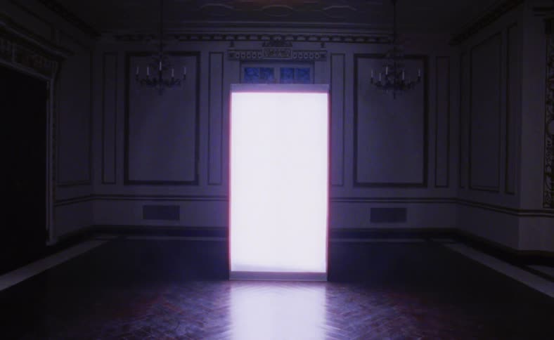 A white screen glows in a dark room