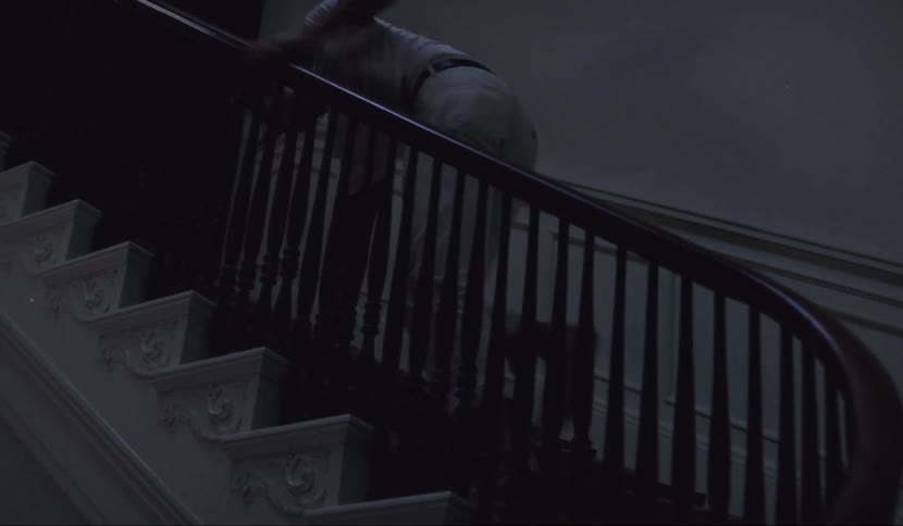 A man stumbles up a flight of steps in a house