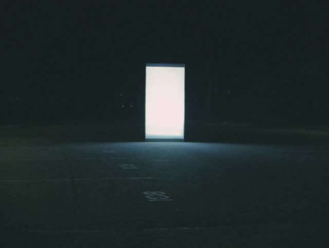 A doorway provides the only light inside a dark dim room