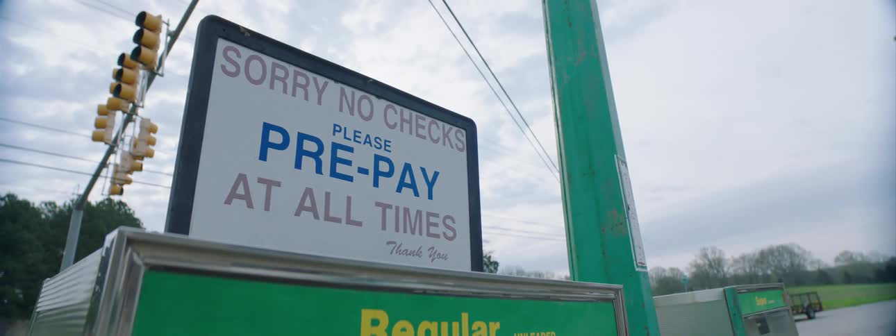A sign on top of an old gas pump