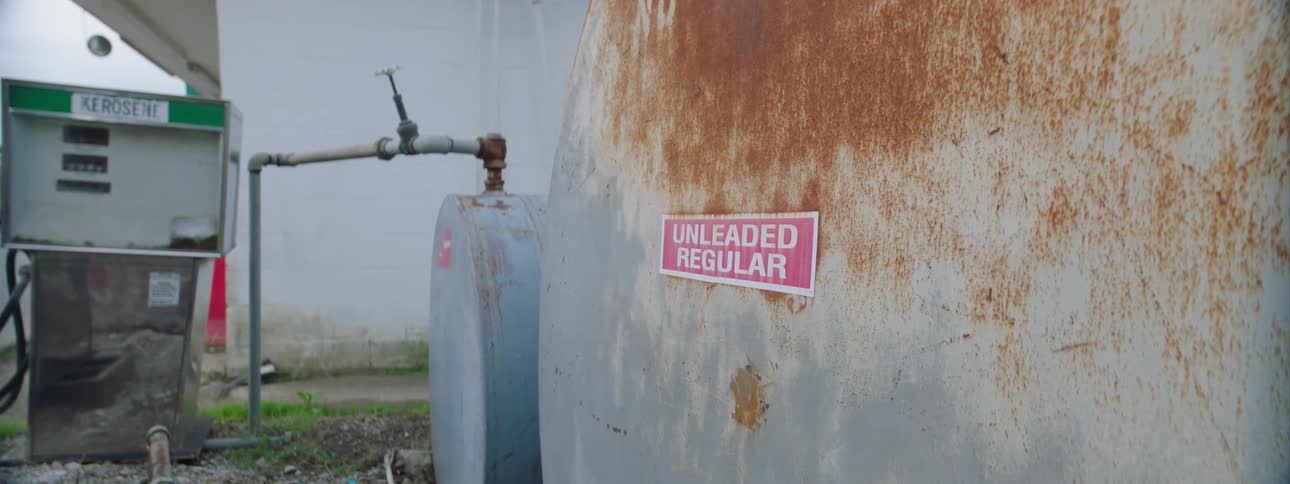 A rusted gasoline tank at a gas station