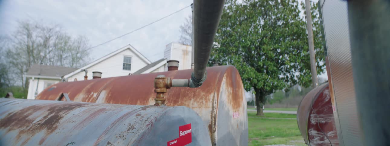 Metallic storage tanks outside warehouse near house