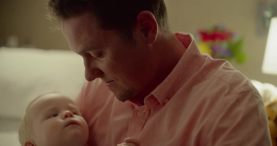 A man sits with his child in his arms