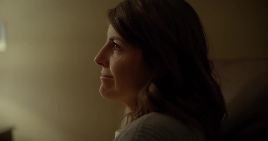 A woman sits up and smiles
