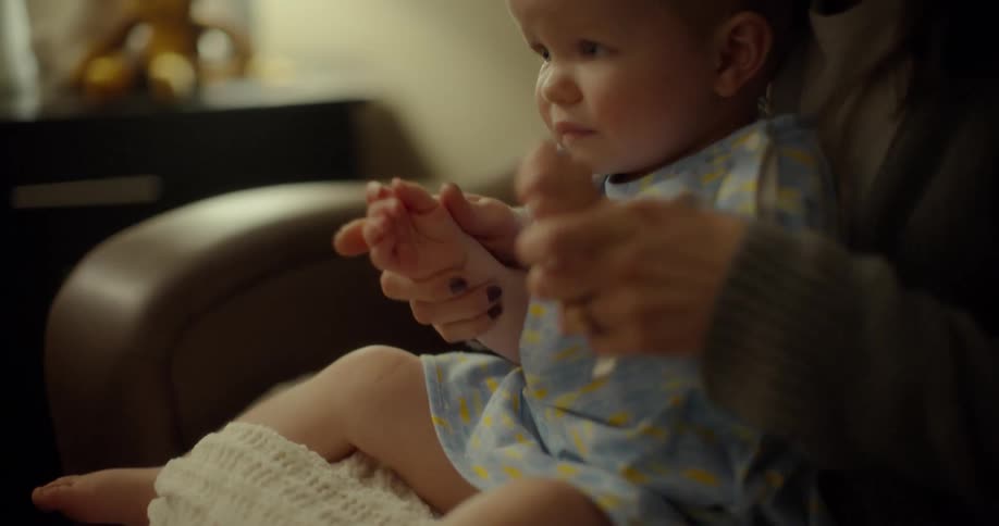 A woman sitting on a couch holding a baby boy in her lap