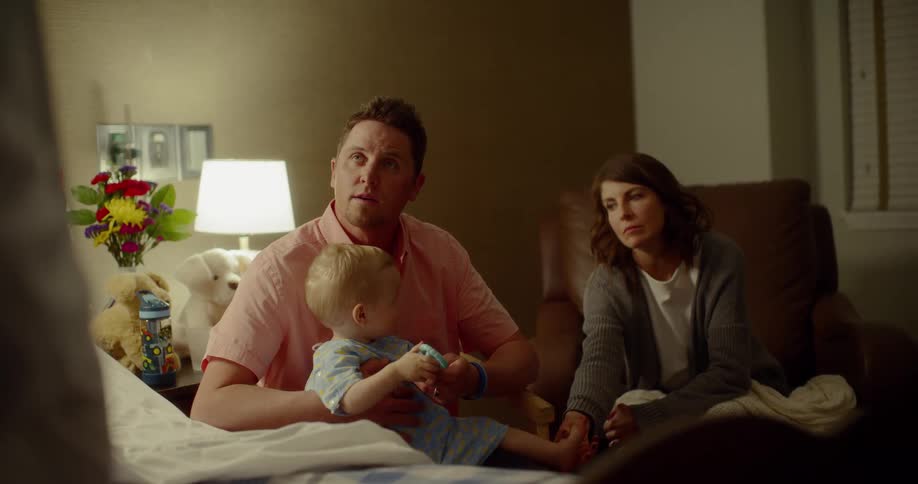Parents sit with their son in the hospital room