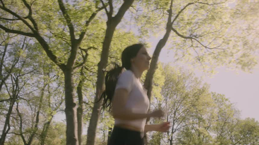 A woman runs in an area with trees