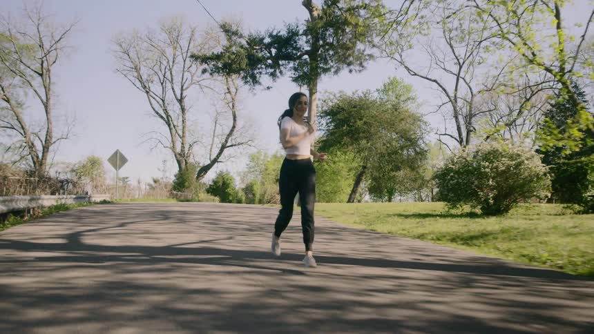 Woman jogs along street past houses