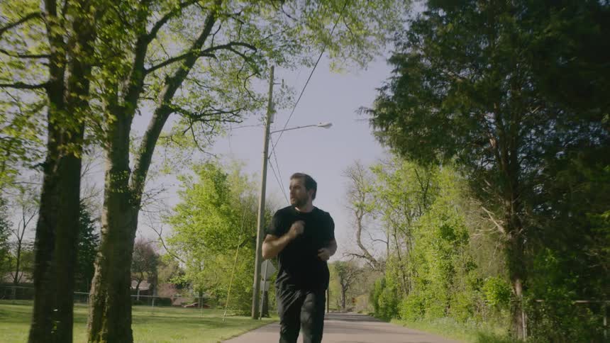 A man jogs down the street in his neighborhood