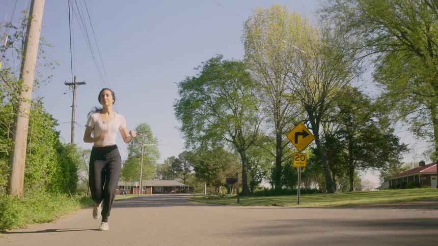 Woman runs along the road in the small town