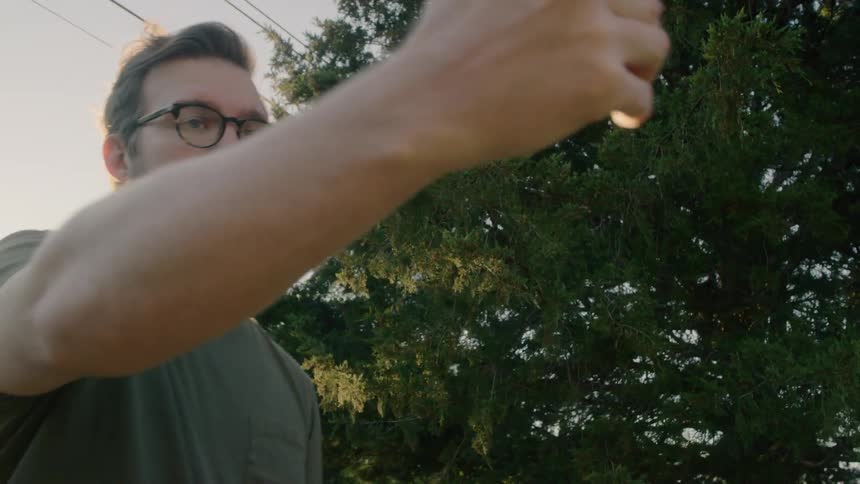 A man using a smartphones outdoors in a neighborhood