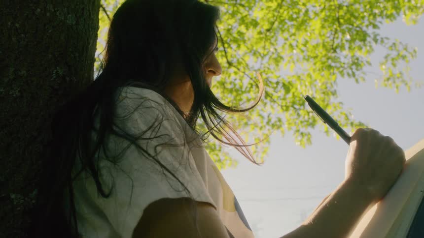 A woman writes down in a notebook